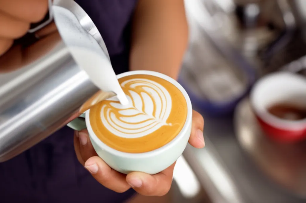 바리스타가 독특한 라떼 아트로 커피를 능숙하게 준비하는 모습